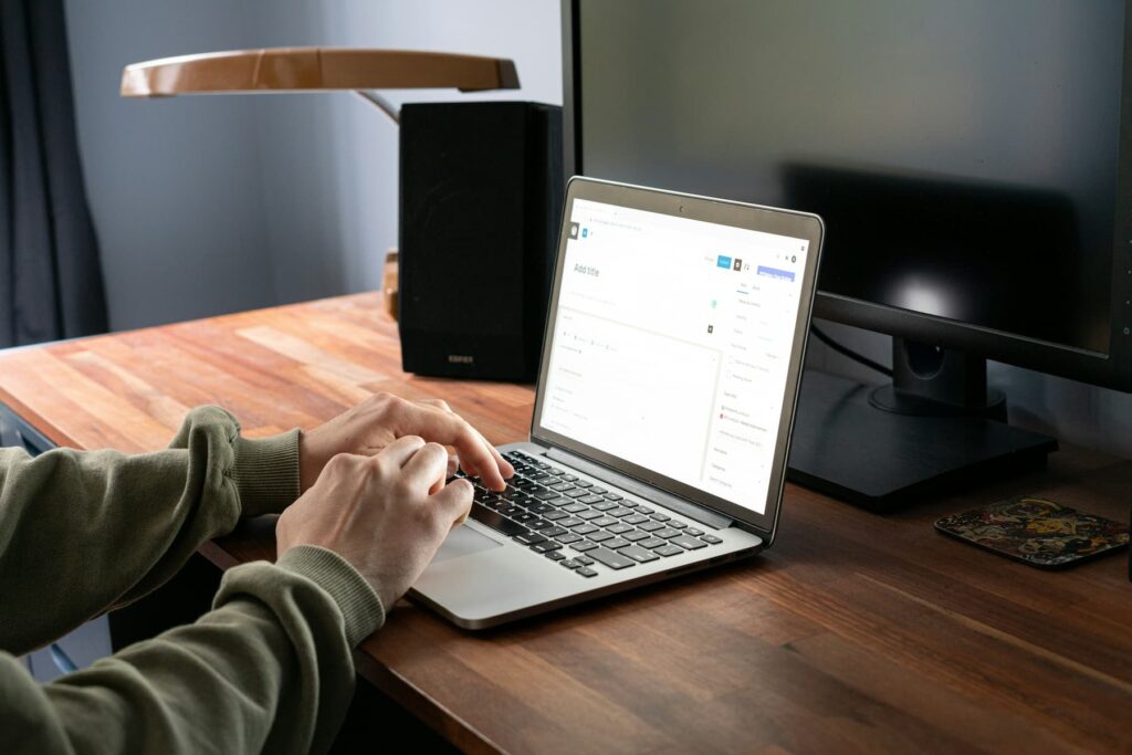 A person using a laptop on a desk.